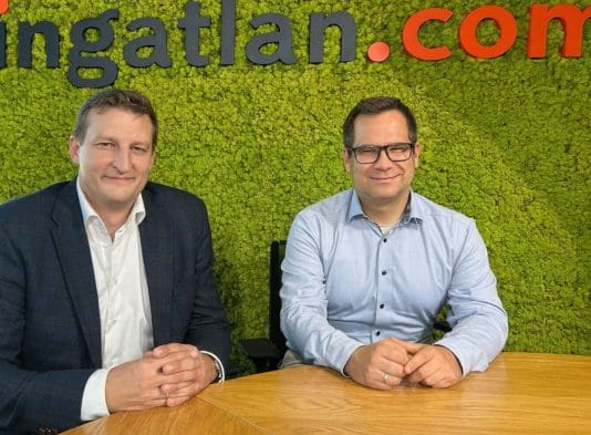 Dr. Panyi Miklós államtitkár (balra) és Balogh László gazdasági szakértő (jobbra) az ingatlan.com stúdiójában. Mögöttük zöld mohafal és az ingatlan.com logója látható.