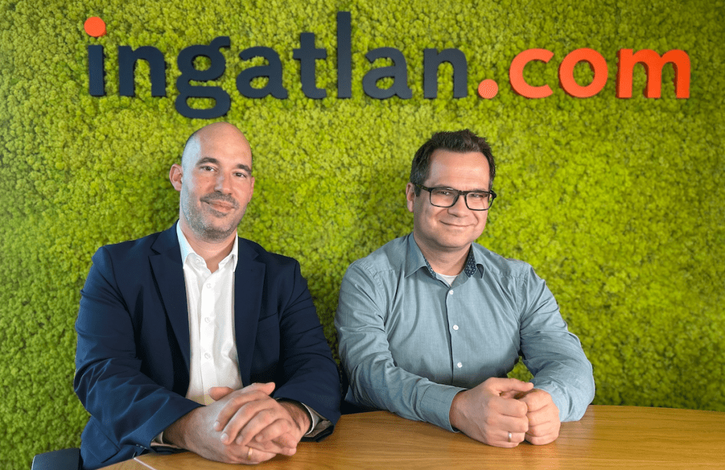 Gürtler László (Raiffeisen Bank) és Balogh László (ingatlan.com) az ingatlan.com podcast stódiójában. Mögöttük mohafal és az ingatlan.com logója.