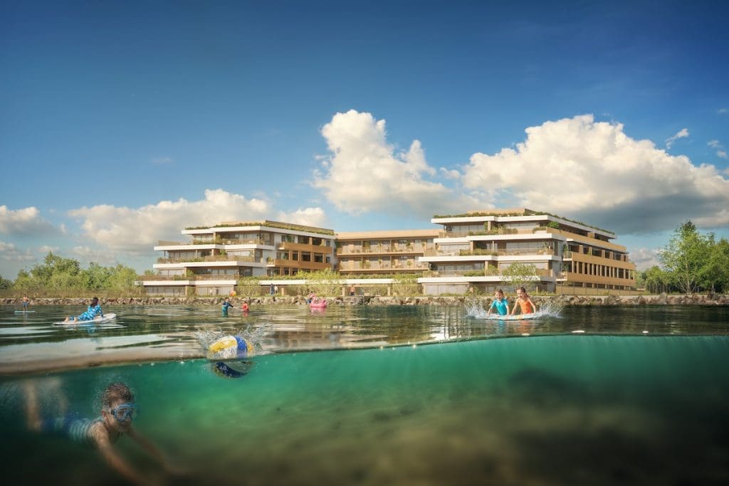 A The View látványterve a víz felőli oldalról. A kép előterében gyerekek fürdenek a Balatonban, mögöttük a lakópark elegáns épülete és kék, bárányfelhős ég látható.