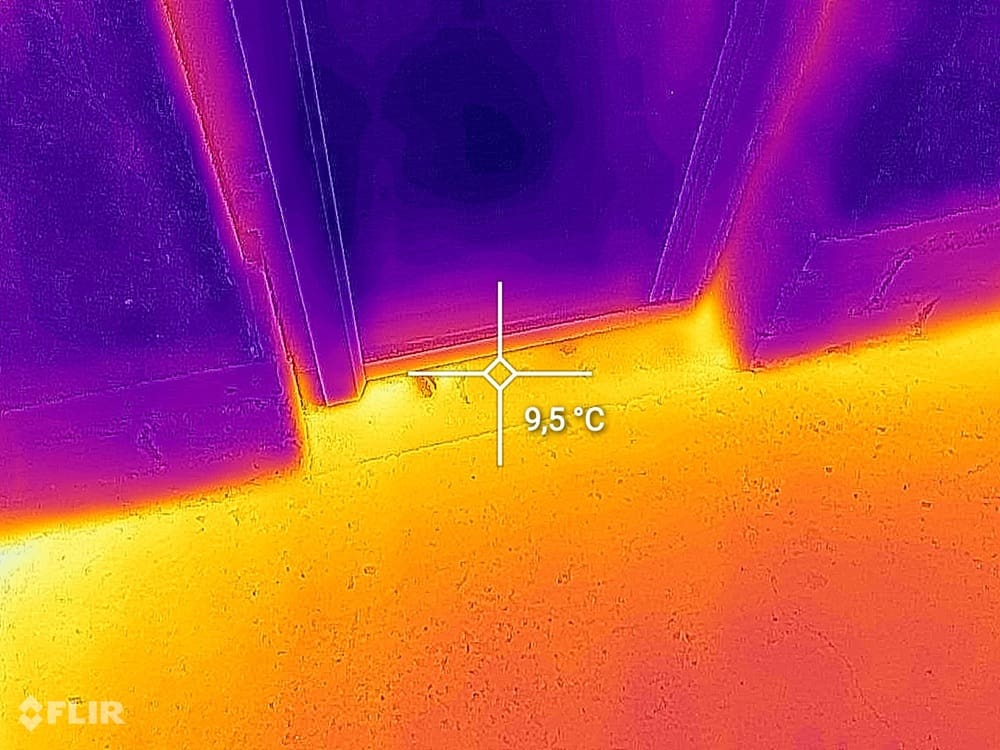 Hőkamrás felvétel egy bejárati ajtóról, amin keresztül kiszökik a hő.