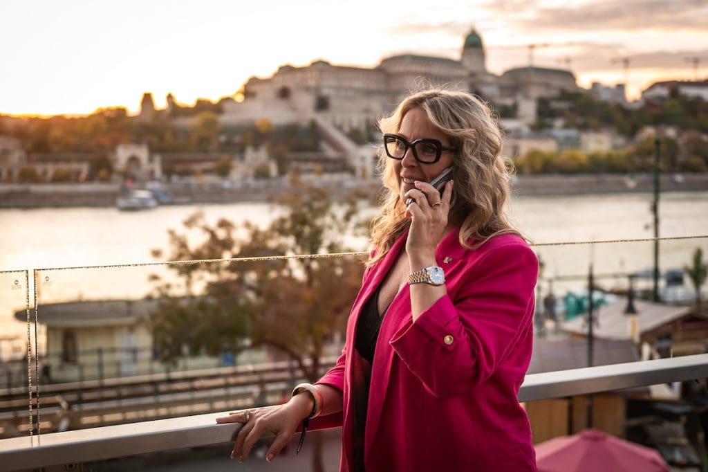 Vörös Eszter, iCompass díjazott ingatlanközvetítő telefonál a Budapest Marriott Hotel teraszán, a Comferencia 2025-ön.