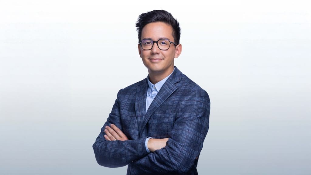 Debrecen ingatlanpiacán tevékenykedő Tran Balázs ingatlanközvetítő portréja szürke színátmenetes háttér előtt.