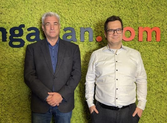 Kiss Ernő, a Magyar Napelem Napkollektor Szövetség elnöke (balra) és Balogh László, az ingatlan.com vezető gazdasági szakértője (jobbra) zöld mohafal előtt. A mohafalon az ingatlan.com logója látható.