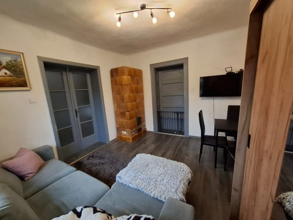 Eladó nyíregyházi családi ház elegáns, modern nappalija, a sarokban hangulatos cserépkályhával.