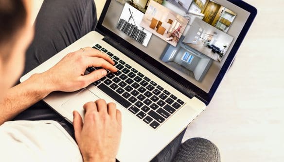 A képen lakást keres egy férfi egy laptop előtt.