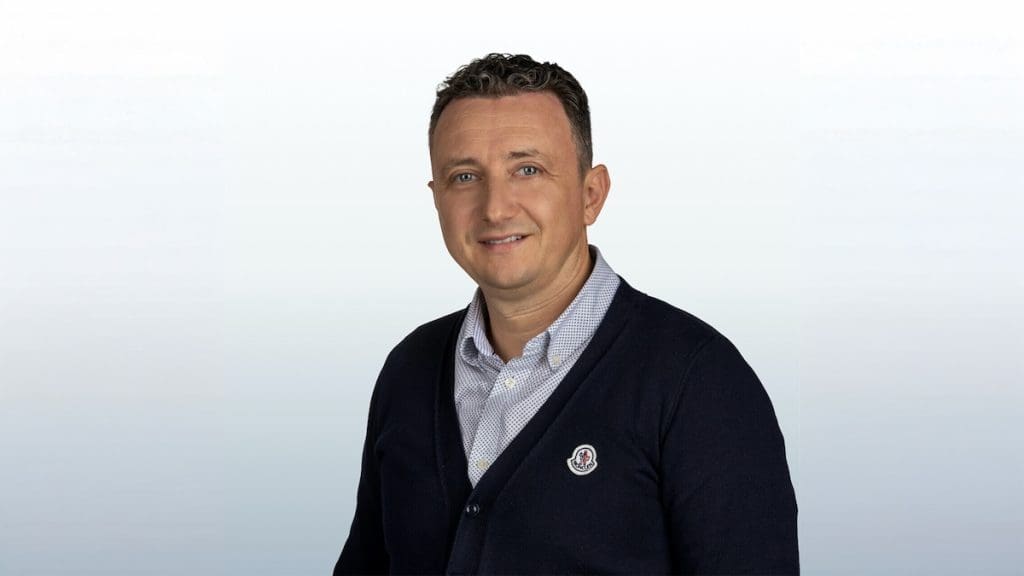 Kopeczky Márton ingatlanközvetítő, a balatoni ingatlanpiac szakértőjének portréja szürke háttér előtt
