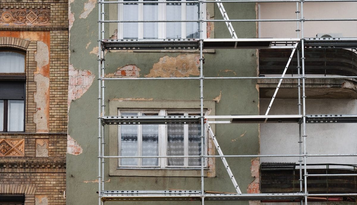Régi budapesti lakóépület sérült homlokzata. Az épület fel van állványozva, feltehetőleg felújítási munkák céljából.