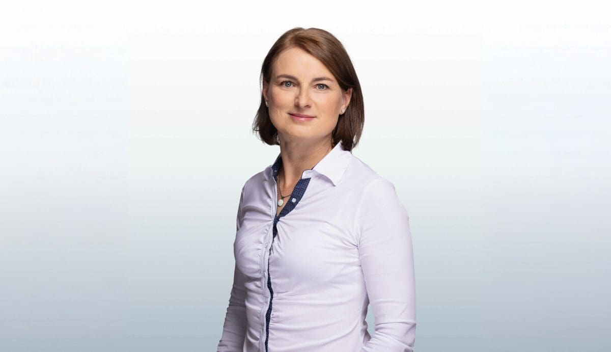 Tóth Rita győri ingatlanközvetítő portréja, szürke színátmenetes háttér előtt.